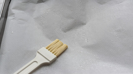 preparing an oven tin with oiled parchment paper 