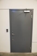 Close up view of grey metal door with digital code lockand extra heavy aluminum commercial door...