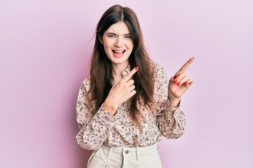 Young beautiful caucasian girl wearing elegant clothes smiling and looking at the camera pointing with two hands and fingers to the side.