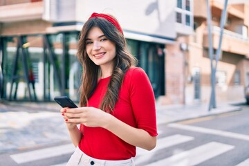 Young caucasian woman smiling happy using smartphone walking at the city.