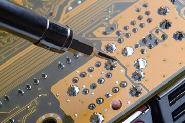Soldering of electronic circuit board with electronic components.  Engineers repair circuit board with soldering iron..