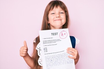 Little caucasian kid girl with long hair showing a passed exam from primary school smiling happy and positive, thumb up doing excellent and approval sign