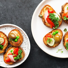 Finger food. Appetizing crostini with baked capsicum, green peas, bacon, kale and lettuce as a festive snack. Top view,