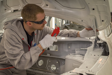 Employee car body painting shop prepares the surface for painting