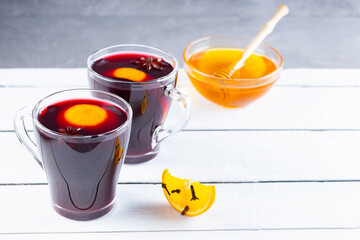 Mulled wine on a boards. Two cups of autumn mulled wine on wooden background. Christmas hot drink. Copy space