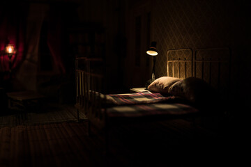 Old vintage single bed at night . A realistic dollhouse bedroom with furniture and window.