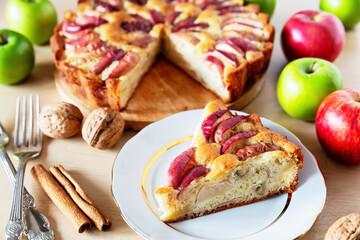 Piece of a tasty apple pie on a white plate, autumn baking concept.