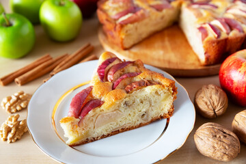 Piece of a tasty apple pie on a white plate, autumn baking concept.