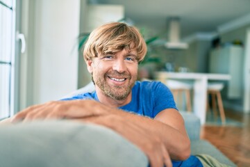 Fototapeta na wymiar Middle age handsome caucasian man relaxing sitting on the sofa at home