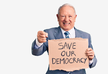Senior handsome grey-haired man holding save our democracy cardboard banner annoyed and frustrated shouting with anger, yelling crazy with anger and hand raised