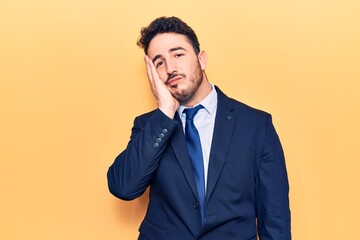 Young hispanic man wearing suit thinking looking tired and bored with depression problems with crossed arms.