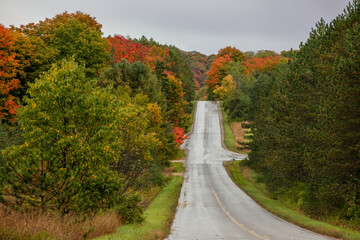 Fall foliage along rural drive in Michigan with overcast sky