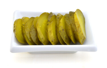 Fresh sliced green pickles in white plate over white