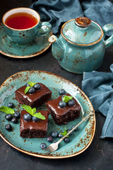Homemade brownies with blueberry, tea cup and teapot