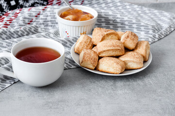 Tasty breakfast. Homemade sweet cinnamon cookies and cup of tea. Apple confiture on background