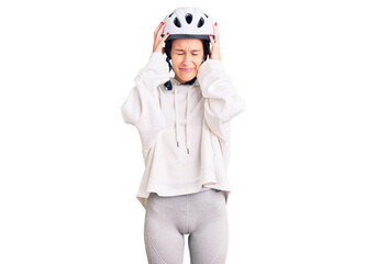 Beautiful brunette young woman wearing bike helmet and sporty clothes suffering from headache desperate and stressed because pain and migraine. hands on head.