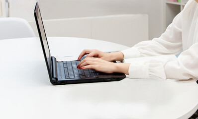 Obraz na płótnie Canvas ノートパソコンのキーボードを打つ女性の手元　
