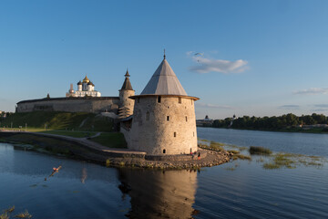 Pskov Kremlin view from river Pskova creek. Towers, wall and Trinity cathedral on background.