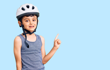 Little cute boy kid wearing bike helmet smiling happy pointing with hand and finger to the side