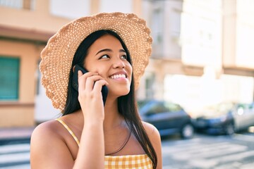 Young asian girl smiling happy at the city speaking on the phone