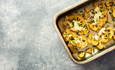 Slices of cauliflower baked with cheese on baking sheet