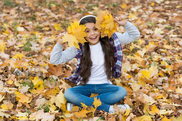 happy teenage girl listen music wearing headphones in autumn forest with beautiful seasonal nature or having online lesson, fun
