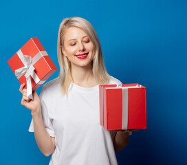 girl in white t-shirt with present box on blue background