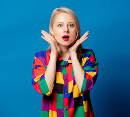Blonde girl in 90s shirt on blue background
