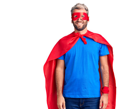Young blond man wearing super hero custome with a happy and cool smile on face. lucky person.