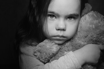Sad girl holding a Teddy bear black and white photo