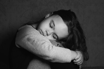 Sad girl put her head on her lap black and white photo