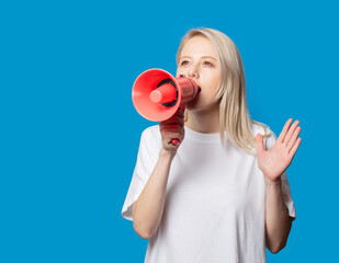 Blonde in white t-shirt with megaphone on blue background
