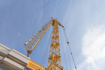 Tower crane at a construction site. Lowered tower crane on sky background
