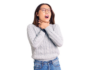 Young beautiful chinese girl wearing casual clothes shouting suffocate because painful strangle. health problem. asphyxiate and suicide concept.