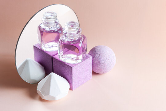 Lavender soap, shampoo and aromatic bath bomb with reflection in a round mirror. Concept for spa, beauty and health salon, cosmetics store. Close up photo on rose background.