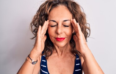 Middle age beautiful brunette woman wearing striped t-shirt standing over white background with hand on head, headache because stress. Suffering migraine.