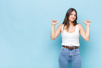 youn pretty woman feeling proud, arrogant and confident, looking satisfied and successful, pointing...