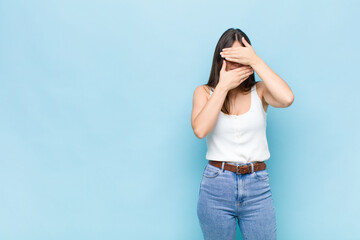 youn pretty woman covering face with both hands saying no to the camera! refusing pictures or...