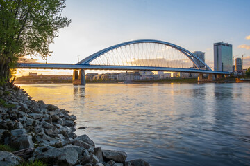 Obraz premium 2020: Long exposure Apollo bridge over river Danube in Bratislava, Slovakia. Sunset, golden hour, dramatic skies. High rise buildings, travel destination
