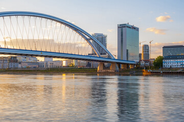 Obraz premium 2020: Long exposure Apollo bridge over river Danube in Bratislava, Slovakia. Sunset, golden hour, dramatic skies. High rise buildings, travel destination