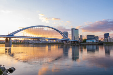 2020: Long exposure Apollo bridge over river Danube in Bratislava, Slovakia. Sunset, golden hour, dramatic skies. High rise buildings, travel destination