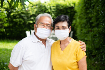 Senior old Asian couple, wearing face mask to protect coronavirus covid-19