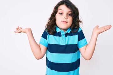 Cute hispanic child with long hair wearing casual clothes clueless and confused with open arms, no idea and doubtful face.