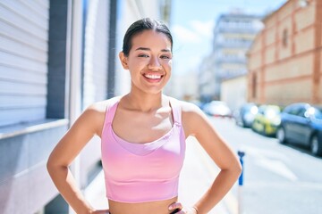 Fototapeta na wymiar Young beautiful hispanic sporty woman wearing fitness outfit smiling happy and natural at the town