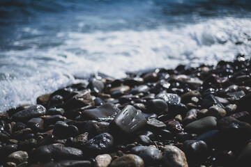 pebble stones by the sea. Silky blue sea waves
