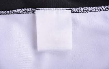 White blank clothing tag label on shirt fabric texture background