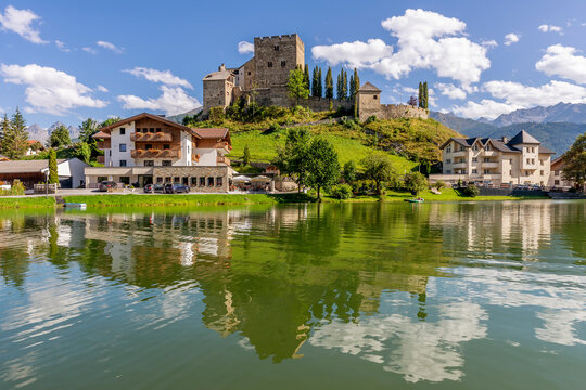 Laudegg Castle is reflected in the lake below on a beautiful sunny day, Ladis, Serfaus, Tyrol, Austria