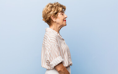 old pretty woman on profile view looking to copy space ahead, thinking, imagining or daydreaming