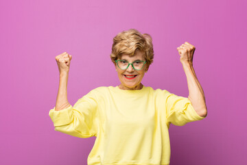old pretty woman shouting triumphantly, looking like excited, happy and surprised winner,...