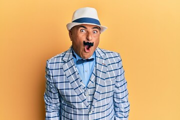 Mature middle east man with mustache wearing vintage and elegant fashion style afraid and shocked with surprise expression, fear and excited face.